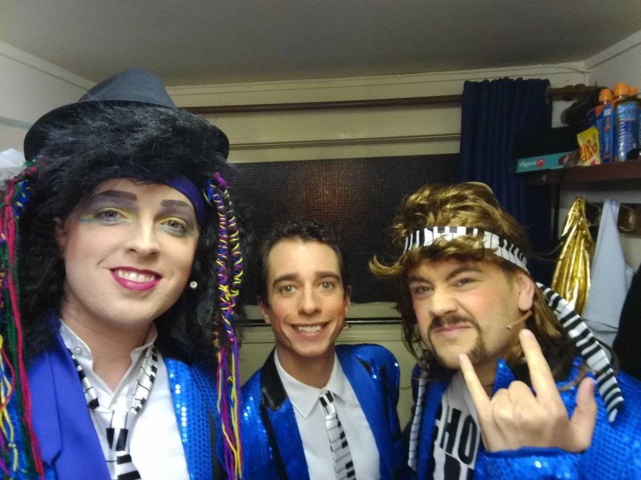 Three actors preparing for a show backstage